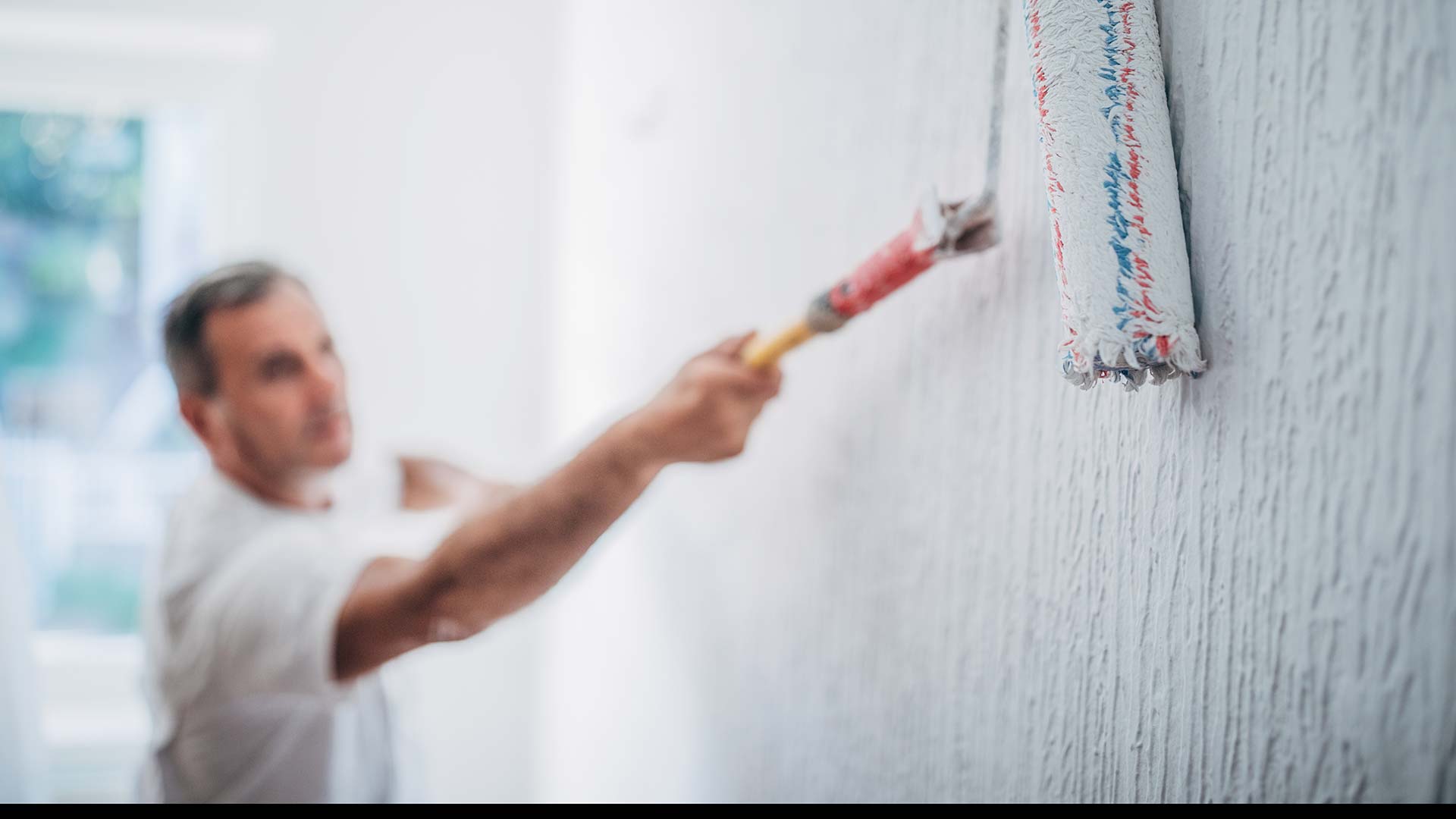 En målare målar en vägg